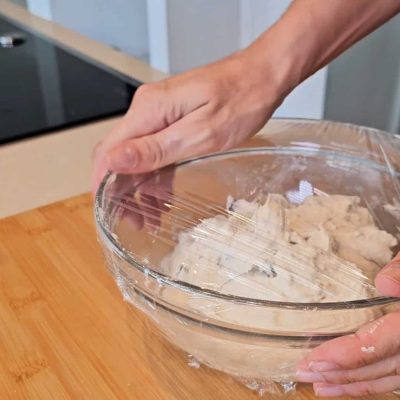 Impasto filoncini alle olive in ciotola coperto da pellicola per lievitazione