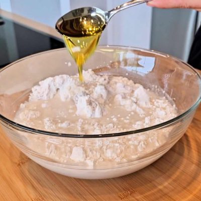 Impasto pane senza glutine con aggiunta di olio in ciotola.