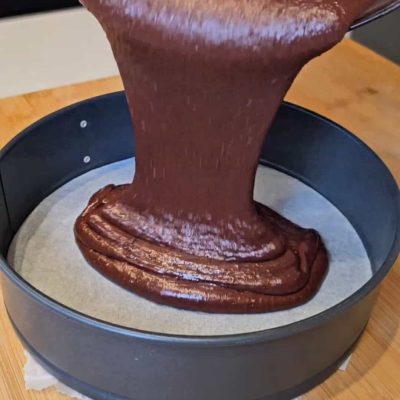 L'impasto della torta al caco senza glutine è versato nella tortiera
