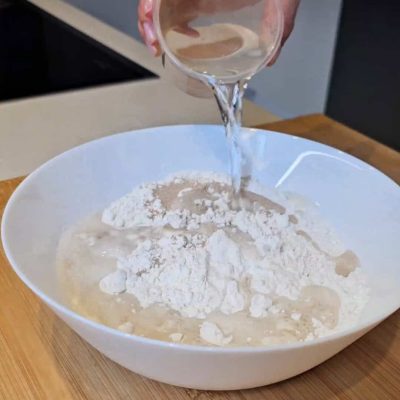 Aggiungo acqua al mix per pane senza glutine per glutine per la focaccia senza glutine alla cipolla caramellata