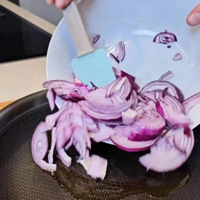 L ecipolle vengono trasferite in padella antiaderente per carammelarle per la focaccia senza glutine alle cipolle caramellate