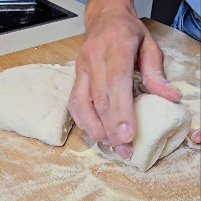 Impasto delle pizzette senza glutine diviso in porzioni uguali pronte da modellare.