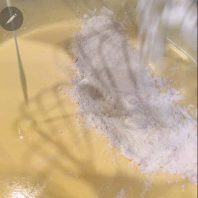 aggiungo le polveri al composto di uova e zucchero delLa mia torta di compleanno senza glutine e senza latte