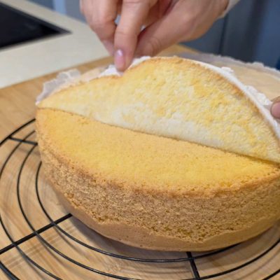 stacco la carta forno dal fondo delLa mia torta di compleanno senza glutine e senza latte