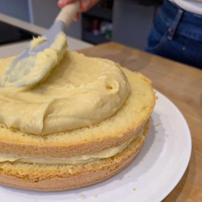 La crema viene spalmata per farcire La mia torta di compleanno senza glutine e senza latte